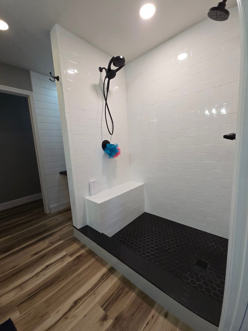 Walk-in shower with subway tile and black hex floor