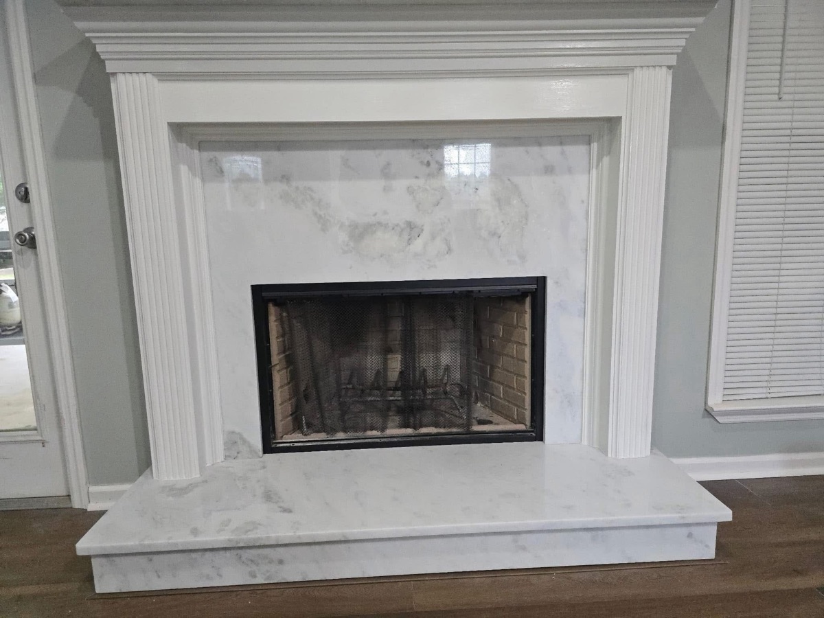 Fireplace remodeled with a marble surround, hearth, and fluted white mantel